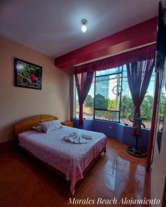 a bedroom with a bed and a large window at Alojamiento Morales Beach in Morales