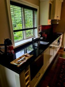 une cuisine avec un comptoir noir et une fenêtre dans l'établissement Matai Huka Boutique Accommodation, à Paraparaumu