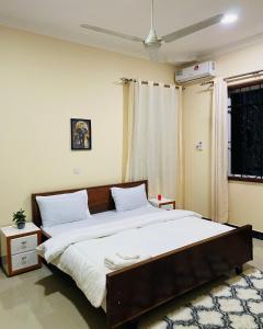 a bedroom with a large bed with white sheets at Boma Hill Residence Apartments by Monalisa in Morogoro +38 photos