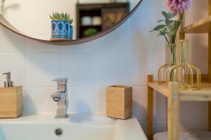 a bathroom sink with a mirror and a vase on it at OG2 L City Wohnung mit Balkon 15min bis Salzburg in Freilassing +12 photos