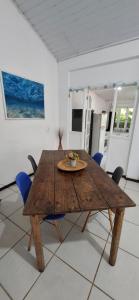 Una mesa y sillas de madera en una habitación. en Apartamento dos coqueiros Búzios, en Búzios 16 fotos más
