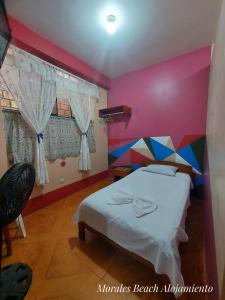 a bedroom with a bed with a colorful wall at Alojamiento Morales Beach in Morales