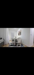 ペヤにあるShoshi Apartmentsのテーブルと白い椅子のあるダイニングルーム