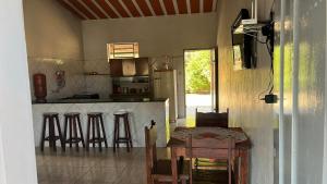 a kitchen with a table and bar with stools at Rancho skalla Capitólio in Capitólio
