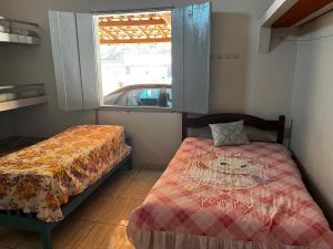 a bedroom with a bed and a window at Rancho skalla Capitólio in Capitólio +13 photos