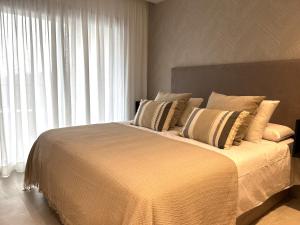Un dormitorio con una cama grande con una ventana grande. en Newly built townhouse with spectacular sea views in an idyllic setting just 15 min from Marbella, en Istán 34 fotos más