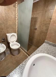 a bathroom with a toilet and a sink and a tub at suite urquiza in Paraná +13 photos