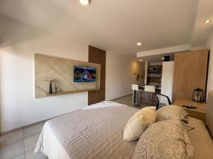 a bedroom with a bed and a kitchen in the background at suite urquiza in Paraná