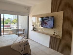 a bedroom with a bed and a tv on a wall at suite urquiza in Paraná