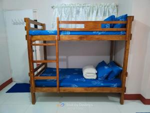 a bunk bed with blue sheets and a ladder at Home by Destiny in Sampong