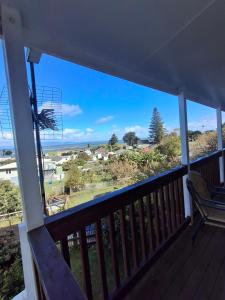 a balcony with a view of the ocean at Classic Kiwi Beach Batch in Tapu +8 photos