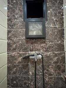a bathroom with a television on a marble wall at La Pause Comfort style in the center in Temara