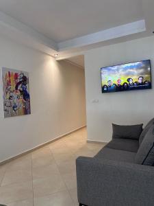 a living room with a couch and paintings on the wall at La Pause Comfort style in the center in Temara