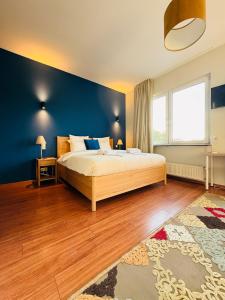 阿尔泽特河畔埃施Auberge Gourmande的卧室里有一张大床和一面蓝色的墙