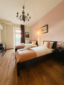 阿尔泽特河畔埃施Auberge Gourmande的一间有两张床和一盏枝形吊灯的卧室 更多10张照片