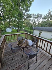 une terrasse en bois avec une table et des chaises dessus dans l'établissement Elena's Lake Cottage - A Cozy Lake Getaway, à Lake Geneva