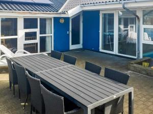 Una mesa y sillas de madera en un patio. en 12 person holiday home in Vestervig-By Traum, en Vestervig