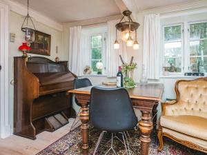 a living room with a piano and a table at 4 person holiday home in Tønder in Tønder