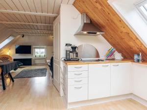 a kitchen with white cabinets and wooden ceilings at 6 person holiday home in Thisted in Thisted