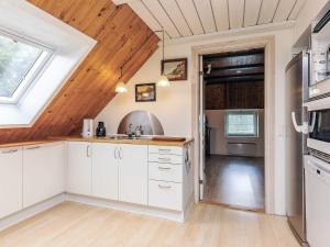 a kitchen with white cabinets and a wooden ceiling at 6 person holiday home in Thisted in Thisted +18 photos
