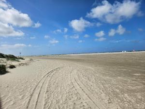een leeg strand met bandensporen in het zand bij 6 person holiday home in Fanø-By Traum in Fanø