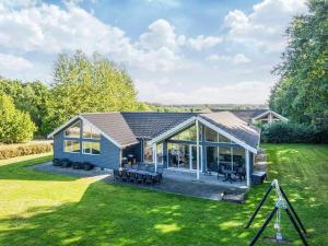 una pequeña casa azul con un gran patio en 16 person holiday home in Glesborg, en Fjellerup Strand
