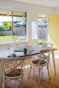 a table and chairs in a room with a window at The Yellow Door Lakehouse in Green Island +7 photos