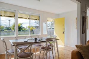 a kitchen and dining room with a table and chairs at The Yellow Door Lakehouse in Green Island