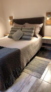 una camera da letto con un letto con cuscini e un tappeto di CasaSur-37Robles-2 a Villa La Angostura