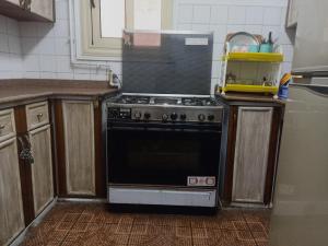 a kitchen with a black stove in a kitchen at Large and comfortable apartment شقة كبيرة و مريحة in Alexandria