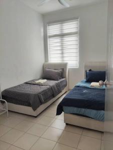 a bedroom with two beds and a window at Townixi Stay in Kampong Jelatang
