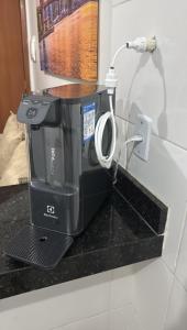 a black coffee maker sitting on a counter at Residencial Leste Universitário in Goiânia