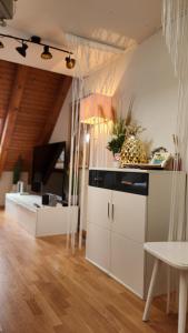 a kitchen with white cabinets and a living room at One and Only Rooftop in Zürich
