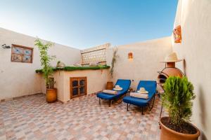 een patio met drie blauwe stoelen en een tafel bij Appart Riad Marrakech in Marrakesh