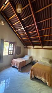 a bedroom with two beds and a wooden ceiling at Chalé Recanto dos pássaros. in Guaraciaba do Norte +26 photos