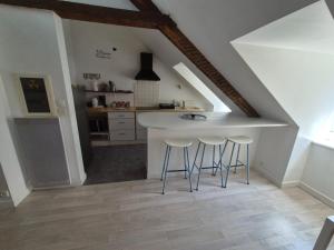 a kitchen with a counter and stools in a attic at L'Écrin Urbain - Centre St Brieuc in Saint-Brieuc