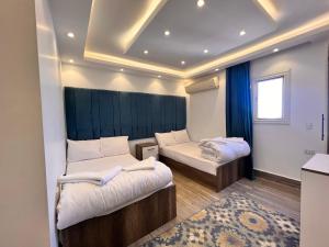 a small room with two beds and a window at Pyramids dream view in Cairo