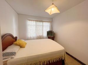 a small bedroom with a bed and a television at Acogedora Casa en Cochabamba in Cochabamba +4 photos