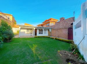 a house with a yard with a green lawn at Acogedora Casa en Cochabamba in Cochabamba