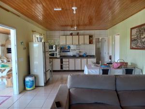 a living room with a couch and a kitchen at Sítio Vô Quirino in Alfredo Wagner