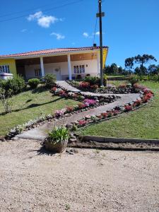 a building with a flower garden in front of it at Sítio Vô Quirino in Barracão