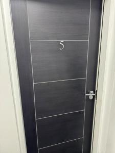 a black door with a number on it at One bed flat Northampton Town 5 in Northampton