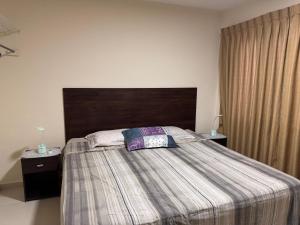 a bedroom with a large bed with a wooden headboard at Sur Backpackers in Santa Cruz de la Sierra