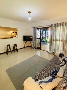 a living room with a couch and a flat screen tv at Flat Yemanjá beira-mar, 4 pessoas, quarto e sala, piscina in Marau
