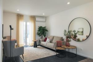 ein Wohnzimmer mit einer Couch und einem Spiegel in der Unterkunft Casa Moderna - New Stylish Home with AC & Patio - Near Beach & Shops in Ribeira Grande