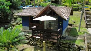 a small house with an umbrella in front of it at Estação Serramar in Lumiar