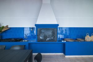 eine blaue Küche mit einem Kamin in der Mitte in der Unterkunft Casa Moderna - New Stylish Home with AC & Patio - Near Beach & Shops in Ribeira Grande