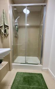 a bathroom with a shower with a green rug at Stylish City Centre Stay with balcony - Near Football Stadiums in Liverpool +7 photos