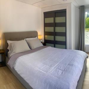 a bedroom with a large bed and a window at Parc de l'Île Melville 1 - Maison flottante in Shawinigan