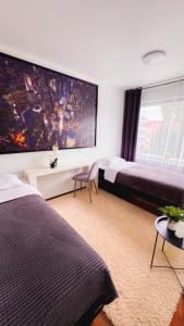 a bedroom with two beds and a large painting on the wall at Oulu city center 4-room apartment Parking in Oulu